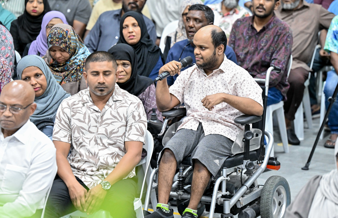 ރައީސް މުއިއްޒު މައްޗަންގޮޅީގެ ރައްޔިތުންނާ ބައްދަލުކުރައްވަން ބޭއްވި ޖަލްސާ އަށް ހާޒިރުވި ހާއްސަ އެހީއަށް ބޭނުންވާ މީހެއްގެ ވާހަކަ ރައީސާ ހިއްސާކުރަނީ.---ފޮޓޯ: ރައީސް އޮފީސް