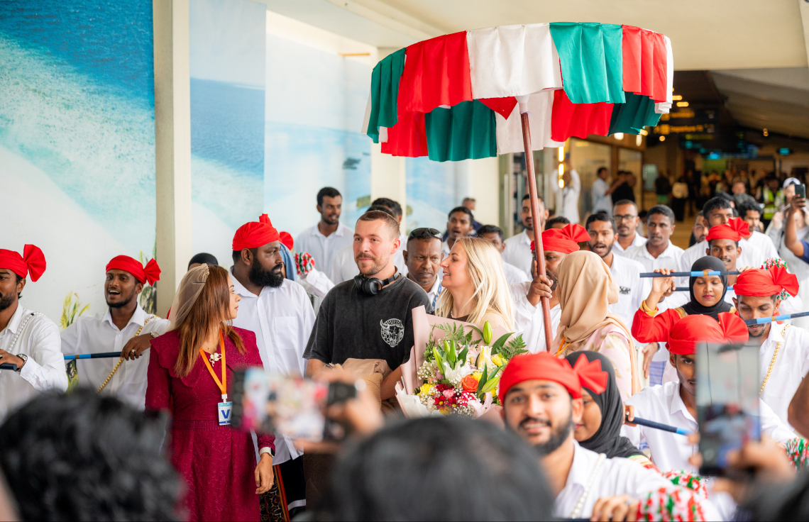 ރާއްޖެ އަށް ޒިޔާރަތްކުރި ދެ މިލިއަން ވަނަ ޓޫރިސްޓުގެ ޝަރަފު ހޯދި އިނގިރޭސި ވިލާތުގެ ބެތަނީ ސާރާ ކާސްވެލް އަށް ދިވެހި ސަގާފީ ހަރަކާތަކުން މަރުހަބާ ކިޔަނީ.---ފޮޓޯ: ނިޝާން އަލީ| މިހާރު