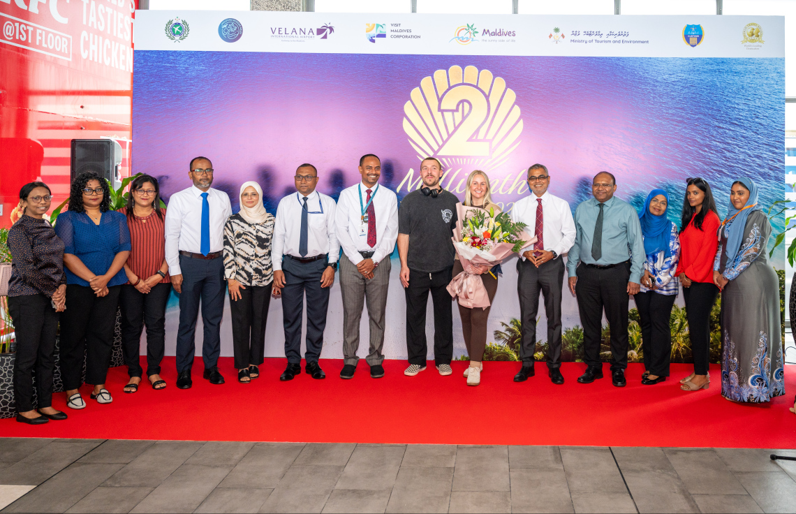 ރާއްޖެ އަށް ޒިޔާރަތްކުރި ދެ މިލިއަން ވަނަ ޓޫރިސްޓުގެ ޝަރަފު ހޯދި އިނގިރޭސި ވިލާތުގެ ބެތަނީ ސާރާ ކާސްވެލްއާ އެކު، ޓޫރިޒަމް މިނިސްޓަރު ތޯރިގާއި އެ މިނިސްޓްރީގެ ބައެއް މުވައްޒަފުން ފޮޓޯއެއް ނަގަނީ.---ފޮޓޯ: ނިޝާން އަލީ| މިހާރު