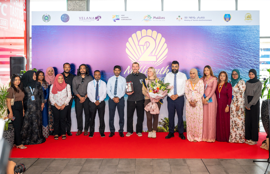 ރާއްޖެ އަށް ޒިޔާރަތްކުރި ދެ މިލިއަން ވަނަ ޓޫރިސްޓުގެ ޝަރަފު ހޯދި އިނގިރޭސި ވިލާތުގެ ބެތަނީ ސާރާ ކާސްވެލްއާ އެކު، ވިޒިޓް މޯލްޑިވްސްގެ އިސްވެރިންނާއި ބައެއް މުވައްޒަފުން ފޮޓޯއެއް ނަގަނީ.---ފޮޓޯ: ނިޝާން އަލީ| މިހާރު