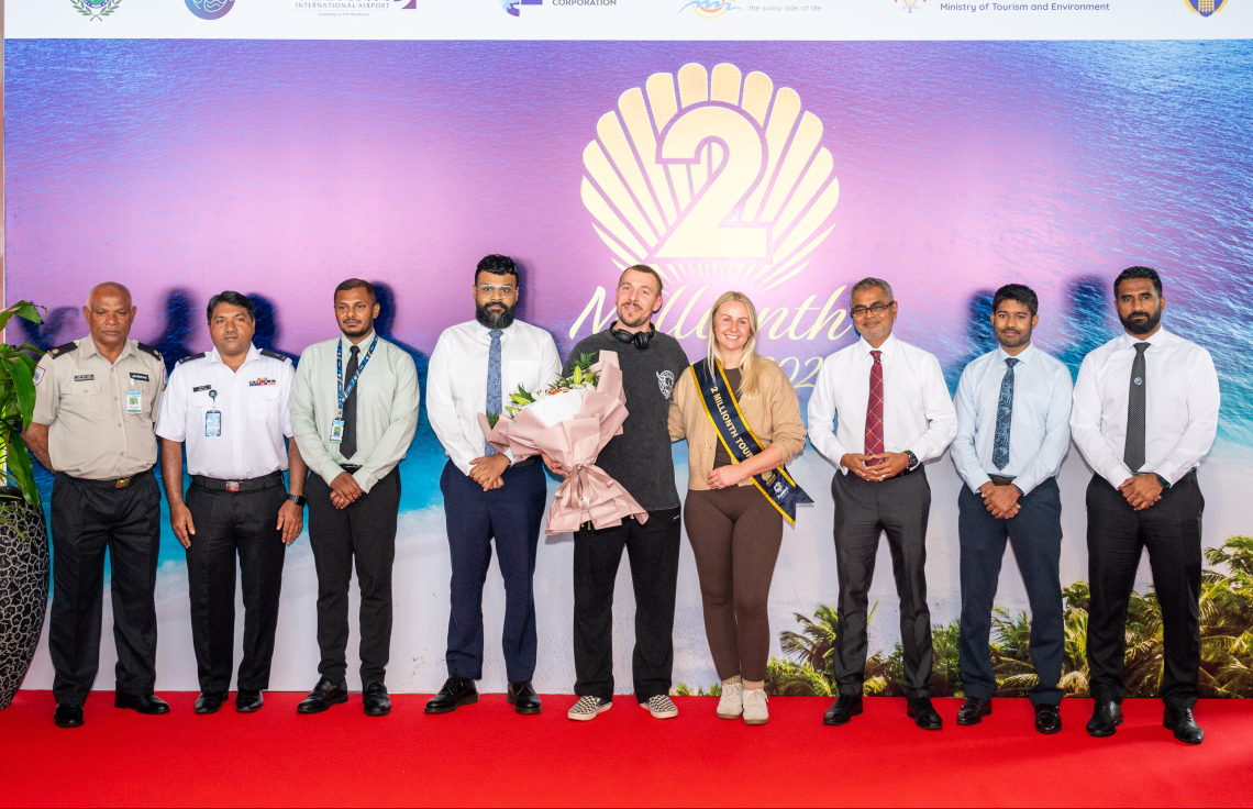 ރާއްޖެ އަށް ޒިޔާރަތްކުރި ދެ މިލިއަން ވަނަ ޓޫރިސްޓުގެ ޝަރަފު ހޯދި އިނގިރޭސި ވިލާތުގެ ބެތަނީ ސާރާ ކާސްވެލްއާ އެކު، ޓޫރިޒަމް މިނިސްޓަރު ތޯރިގާއި އެމްއެމްޕީއާރުސީގެ މެނޭޖިން ޑިރެކްޓަރު އިބްރާހީމް ޝިއުރީ އާއި އިމިގްރޭޝަން އަދި ކަސްޓަމްސްގެ ބައެއް އިސްވެރިން ފޮޓޯއެއް ނަންގަވަނީ.--- ފޮޓޯ: ނިޝާން އަލީ | މިހާރު