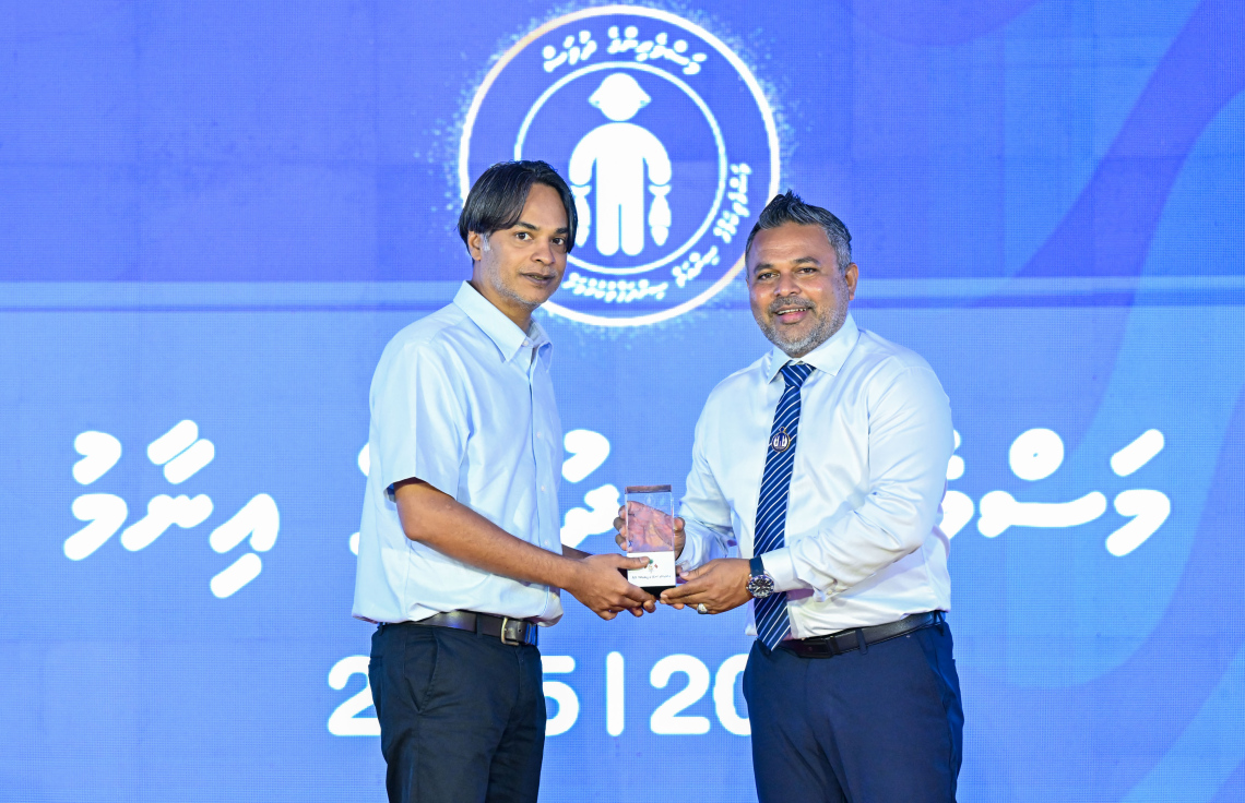 މަސްވެރިންގެ ދުވަސް ފާހަގަކުރަން ދުވާފަރުގައި ރޭ ބޭއްވި ޖަލްސާގައި މަސްވެރިއަކަށް މިނިސްޓަރު އަހްމަދު ޝިޔާމް އިނާމު ދެއްވަނީ.---ފޮޓޯ: ރައީސް އޮފީސް