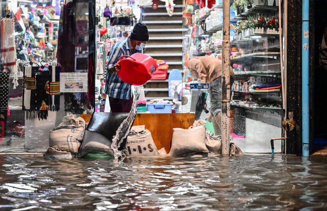 ޖެނުއަރީ 3، 2025: މާލެ އަށް ކުރި ގަދަ ވިއްސާރާގައި ފެންބޮޑުވެ، މަޖީދީ މަގުގައި ހިންގާ ފިހާރައަކަށް ފެން ވަނުމުން އެ ތަނުން ފެން ހިއްކުމުގެ މަސައްކަތް މީހަކު ކުރަނީ: އެއީ މި ފަހުން މާލޭގައި އެންމެ ބޮޑަށް ފެންބޮޑުވި ފަހަރު.--- ފޮޓޯ: ނިޝާން އަލީ | މިހާރު
