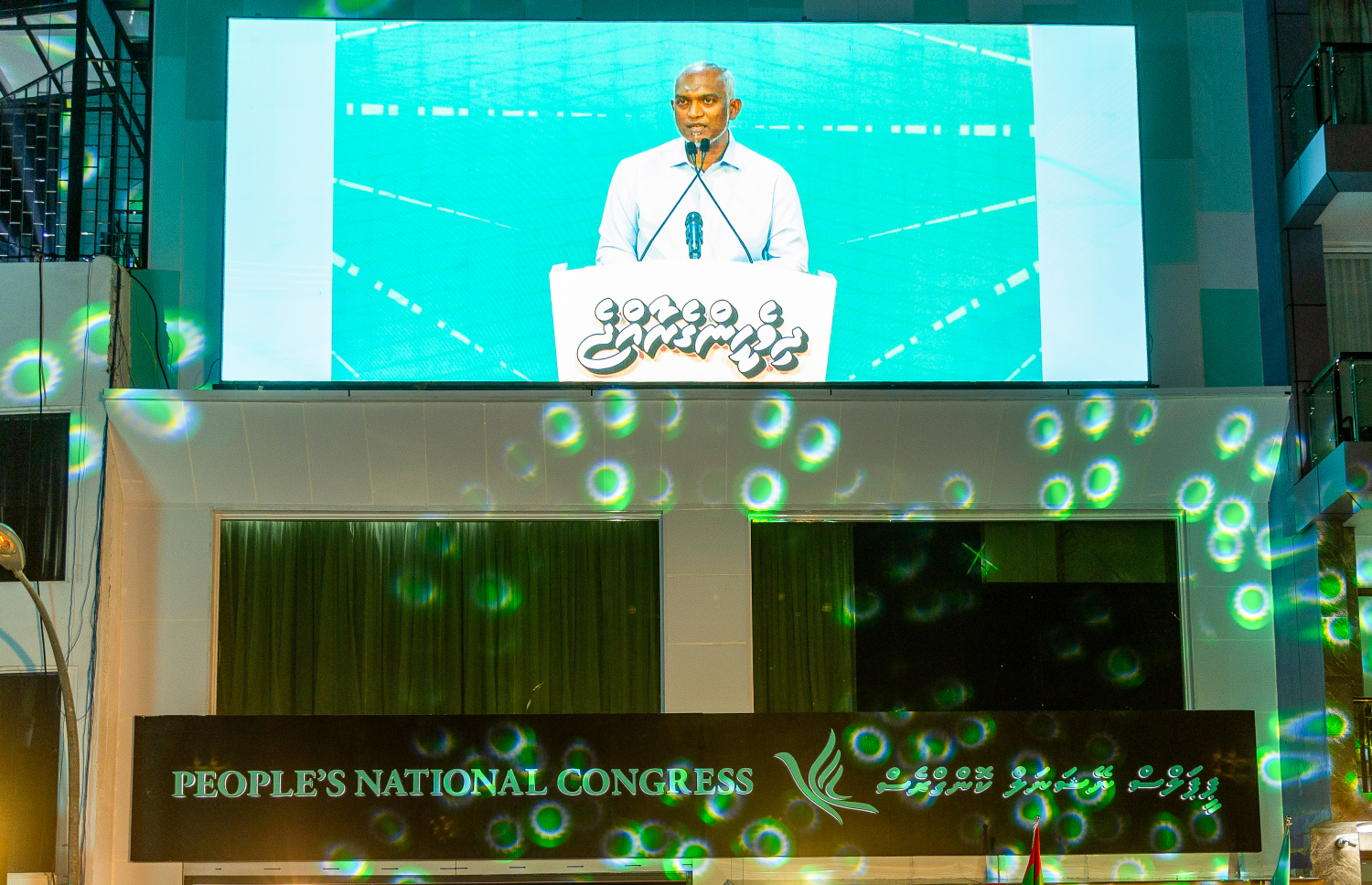 ޕީއެންސީ އޮފީސް ރަސްމީކޮށް ހުޅުވުމުގެ ހަފުލާގައި ރައީސް މުއިއްޒު ވާހަކަފުޅު ދައްކަވާއިރު، ޖަގަހައިހެ ބޭރުގައި ބޮޑު ސްްކްރީން އަޅުވާފައި.---ފޮޓޯ: މިހާރު